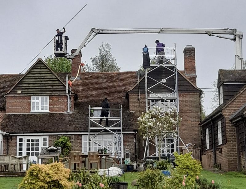 The Moss Cleaners using cherry picker and scaffolding to clean roof safely and professionally in Whitebushes, Surrey